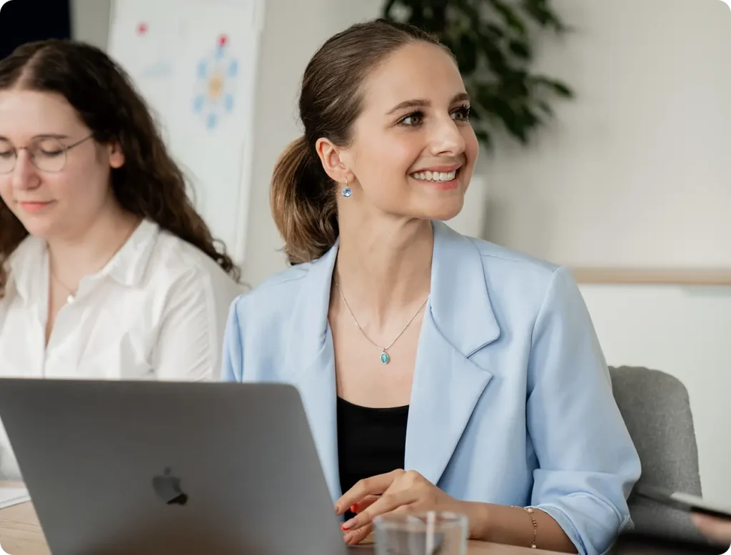 Businesswoman smiling during a meeting while using a laptop